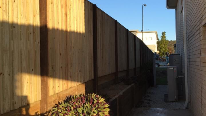 Timber paling fence down a side path